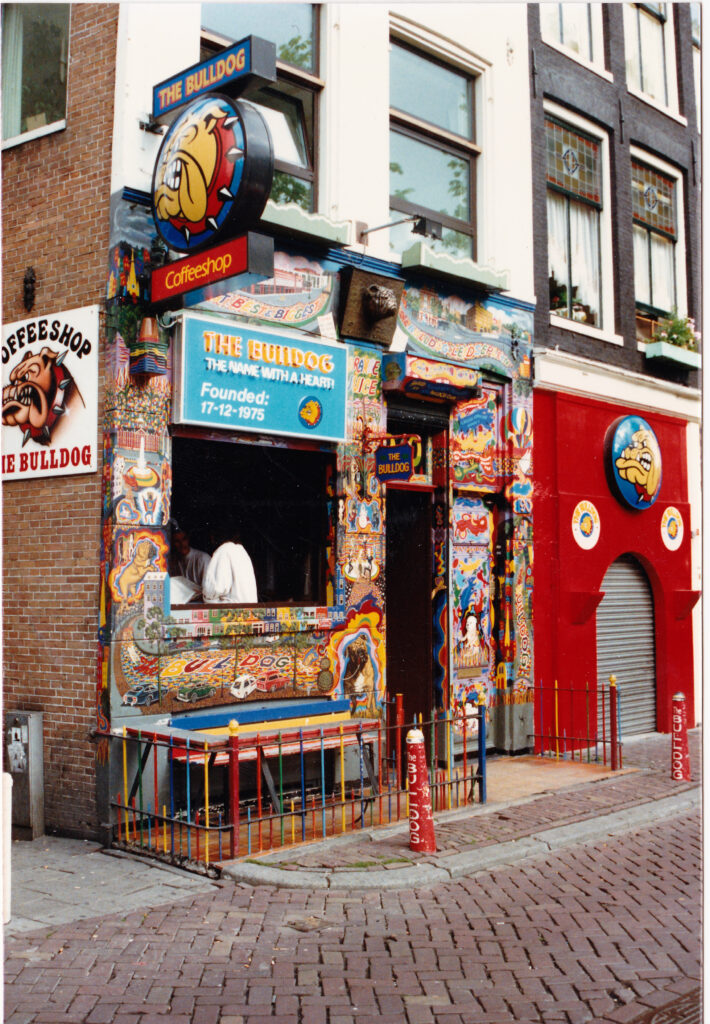 The Bulldog changed amsterdam: Colour photo of The Bulldog Amsterdam’s original coffeeshop façade, fully painted with psychedelic murals, Bulldog signage, and open window service.